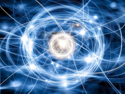 Abstract digital illustration of an atom, featuring glowing particles and swirling blue and white energy lines orbiting a bright central core, symbolizing atomic structure, electron spin, or quantum energy.